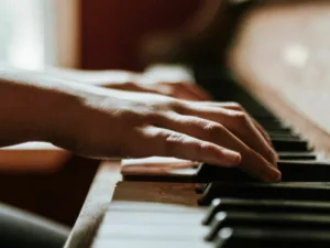 Hands playing a piano from up close