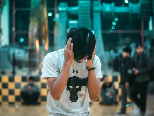 A man covering his ears to muffle the sound of avoid notes.