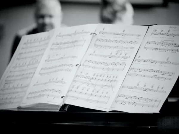 A set of lead sheets sprawled out across a piano.