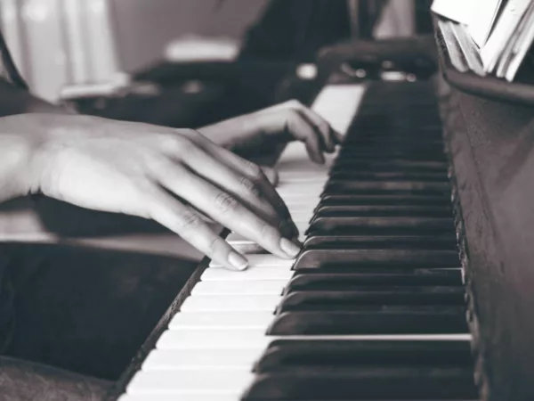 A woman playing an upright piano