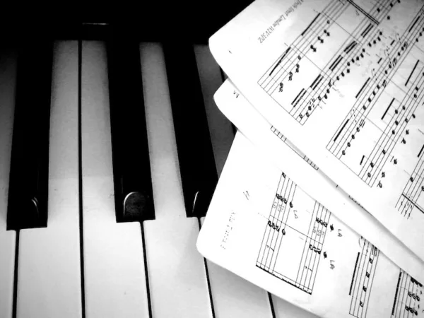 Sheet music laid across the piano keyboard.